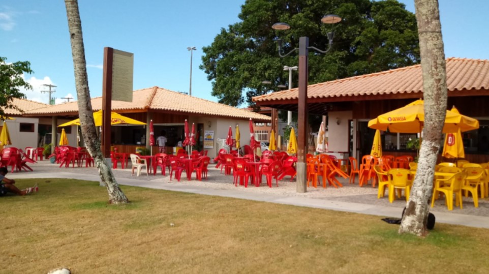 Praça e orla de Cacha-Pregos, com bancos, coqueiros e calçamento